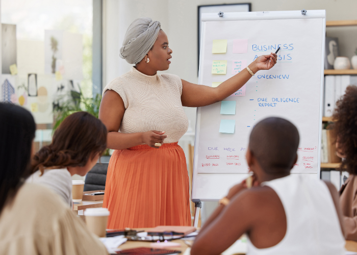 Businesswoman presenting accounting strategies for startups on a whiteboard during a seminar.